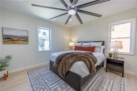 a bedroom with a bed lamp and a potted plant
