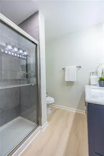 a bathroom with a granite countertop sink a toilet and shower