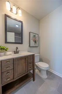 a bathroom with a toilet a sink and mirror