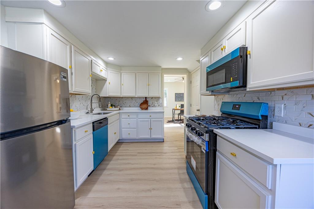 117 Oak Avenue Penn Hills, PA 15235 - Photo 8 of 26 a kitchen with stainless steel appliances granite countertop a stove top oven a refrigerator a sink and dishwasher with wooden floor