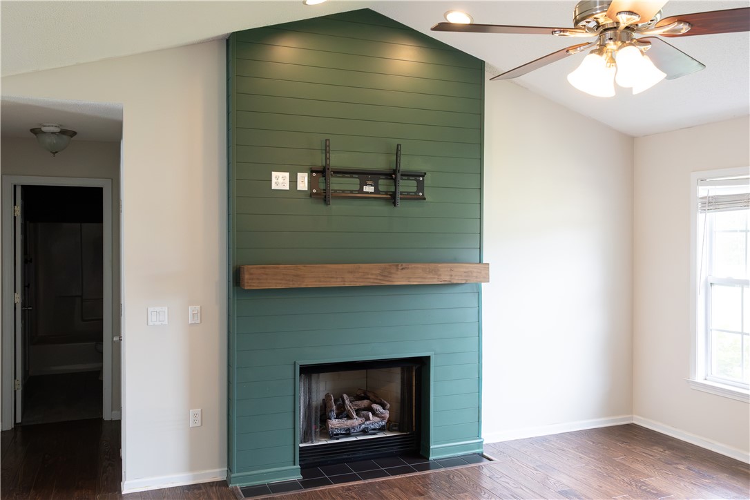 439 Chetola Road Seneca, SC 29672 - Photo 12 of 28 Vaulted ceilings and rich wood floors frame a focal fireplace with a rustic mantel piece.