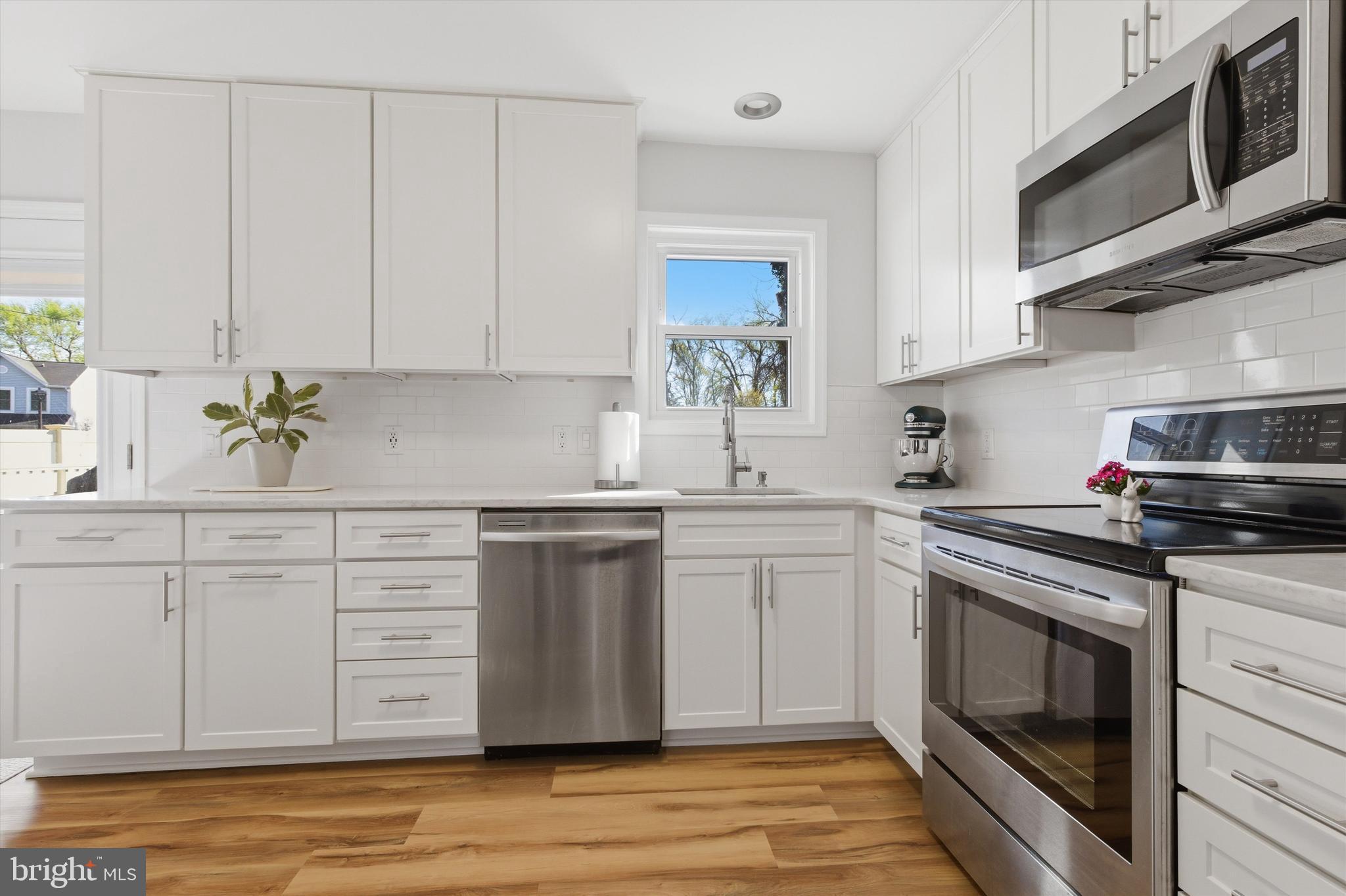 101 Cottage Grove Drive Pasadena, MD 21122 - Photo 11 of 35 a kitchen with stainless steel appliances granite countertop a sink and a stove top oven