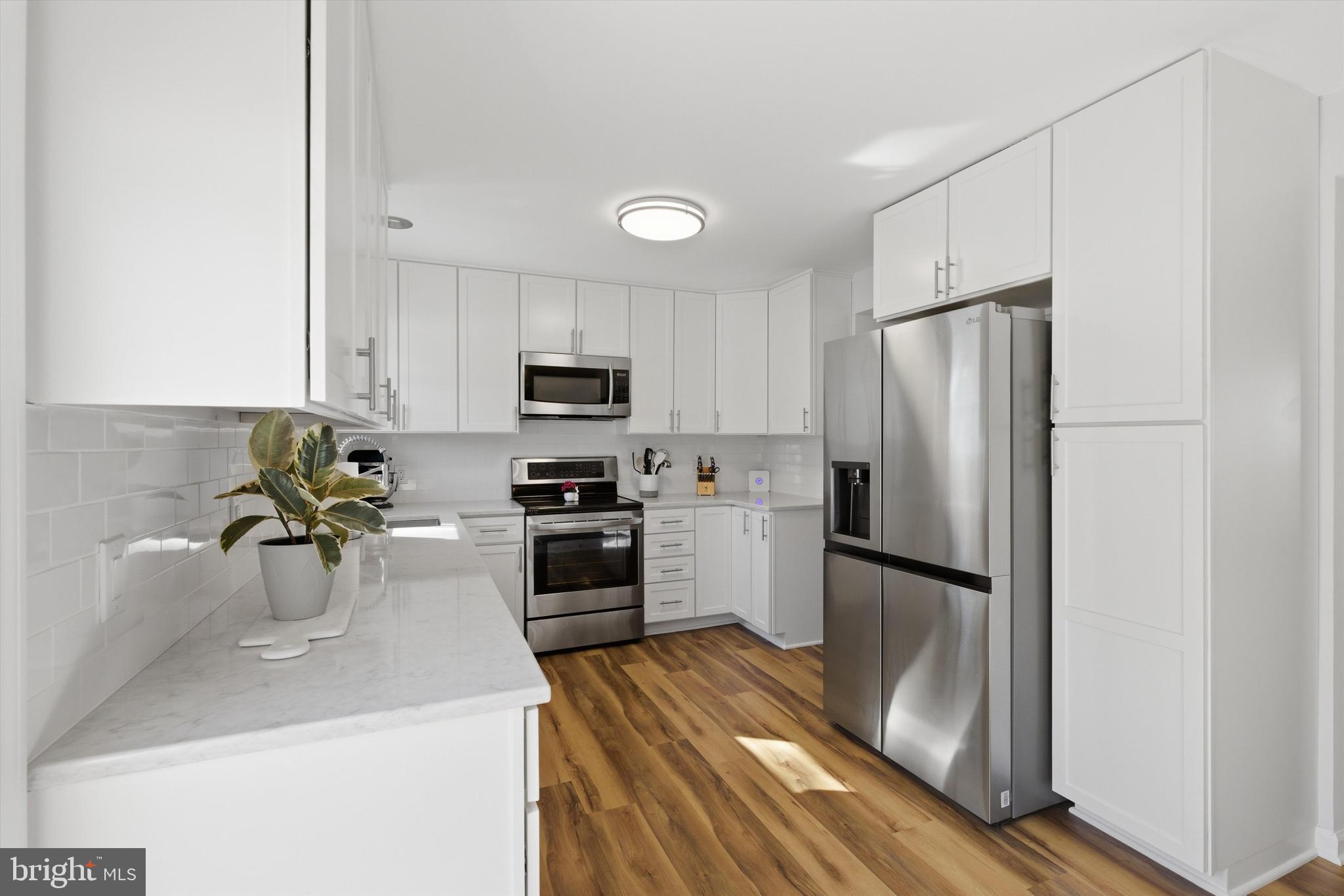 101 Cottage Grove Drive Pasadena, MD 21122 - Photo 12 of 35 a kitchen with a refrigerator sink and white cabinets