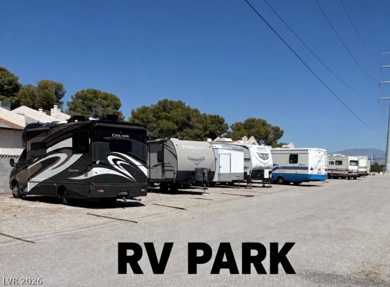 4556 Royal Ridge Way Las Vegas, NV 89103 - Photo 47 of 49 Ample parking spaces accommodate recreational vehicles against a backdrop of mature trees and clear blue skies.
