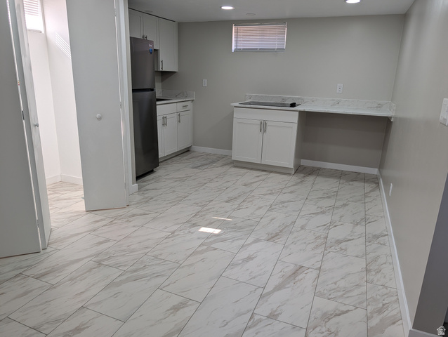 2880 Merton Way Magna, UT 84044 - Photo 11 of 30 Spacious room featuring large format tile flooring, white shaker cabinetry, light-toned countertops, and a modern stainless steel refrigerator