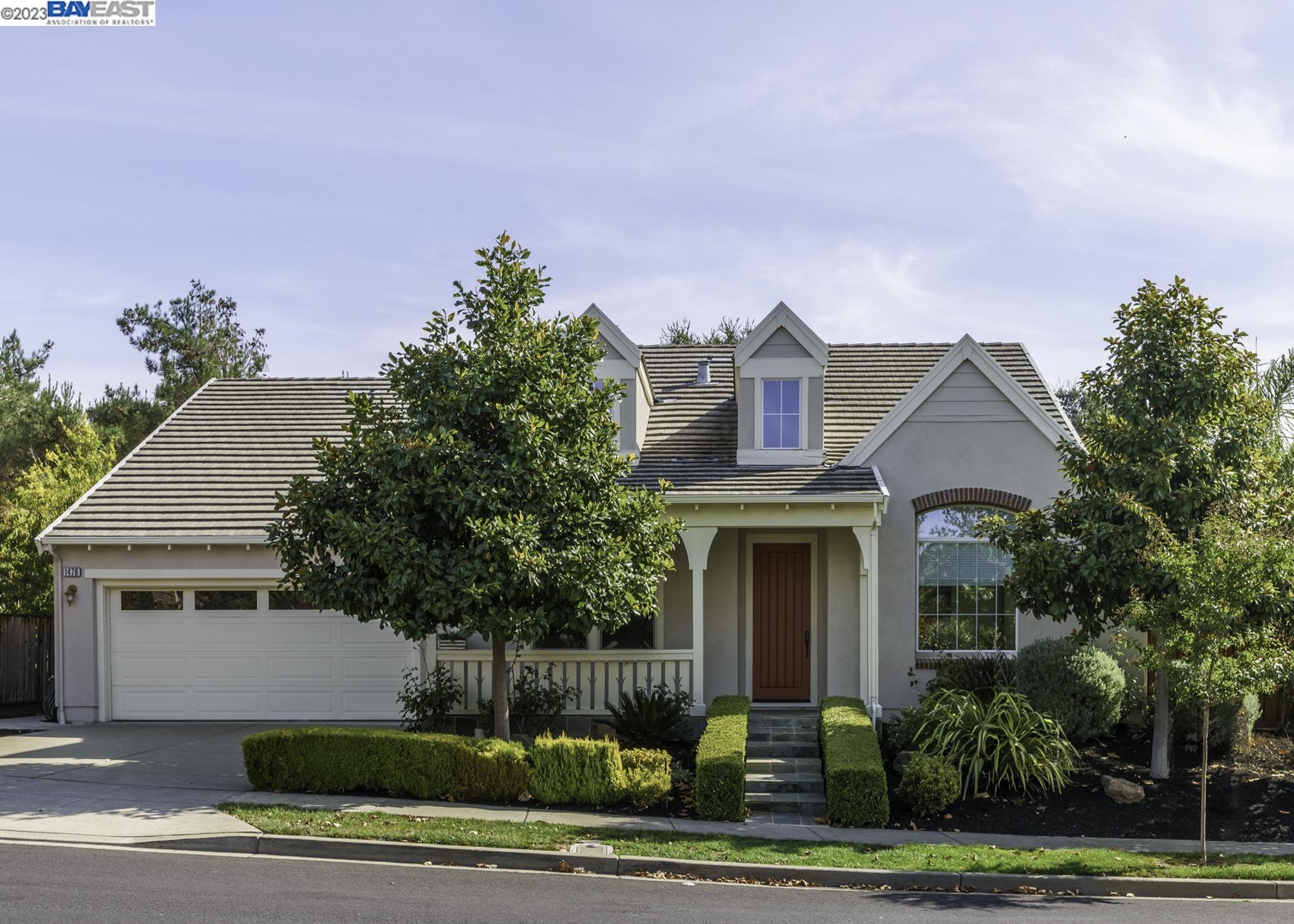 a front view of a house with a garden and plants