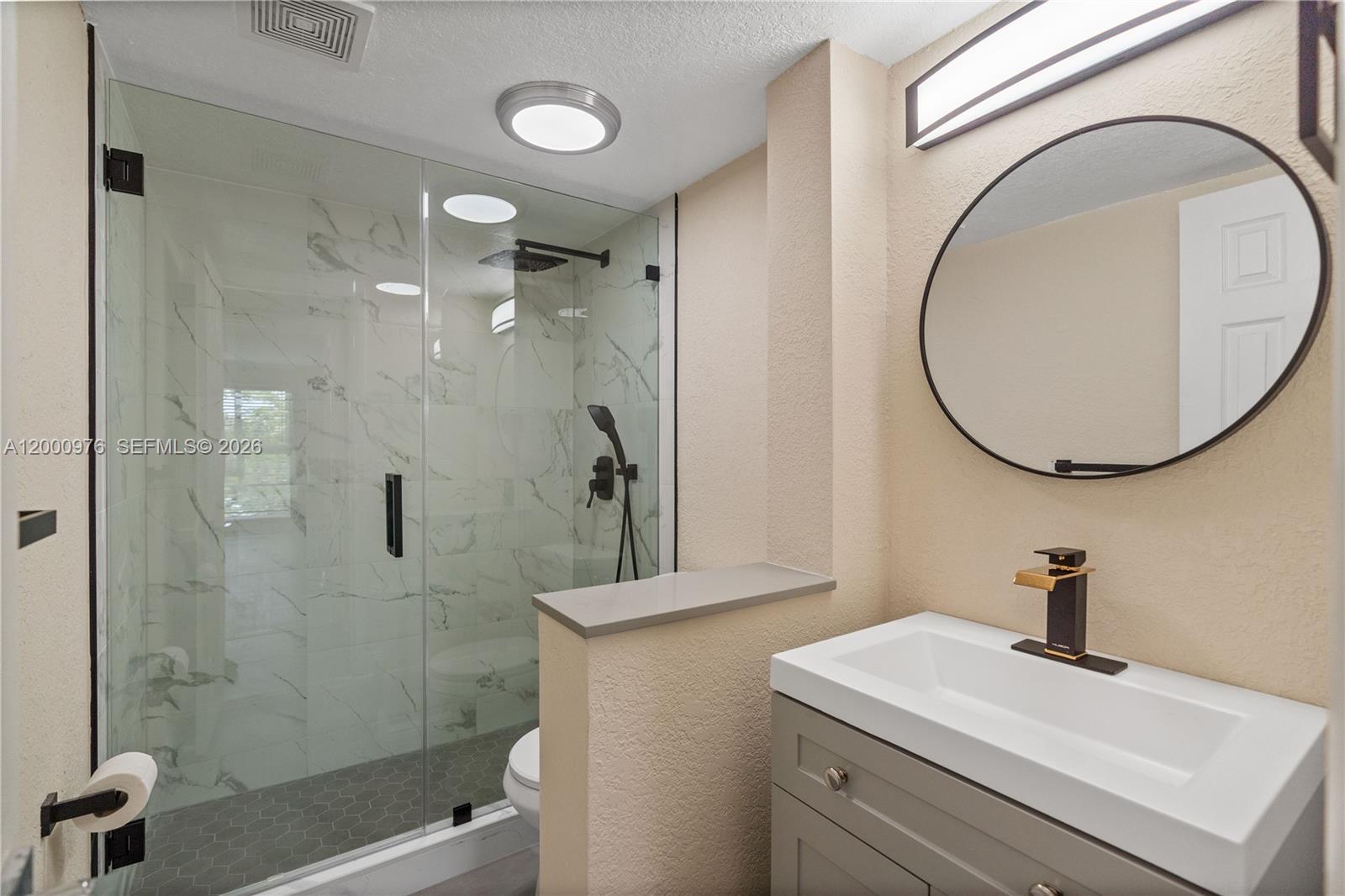 9441 Southwest 76th Street, Unit V32 Miami, FL 33173 - Photo 3 of 28 a bathroom with a sink a shower and a mirror