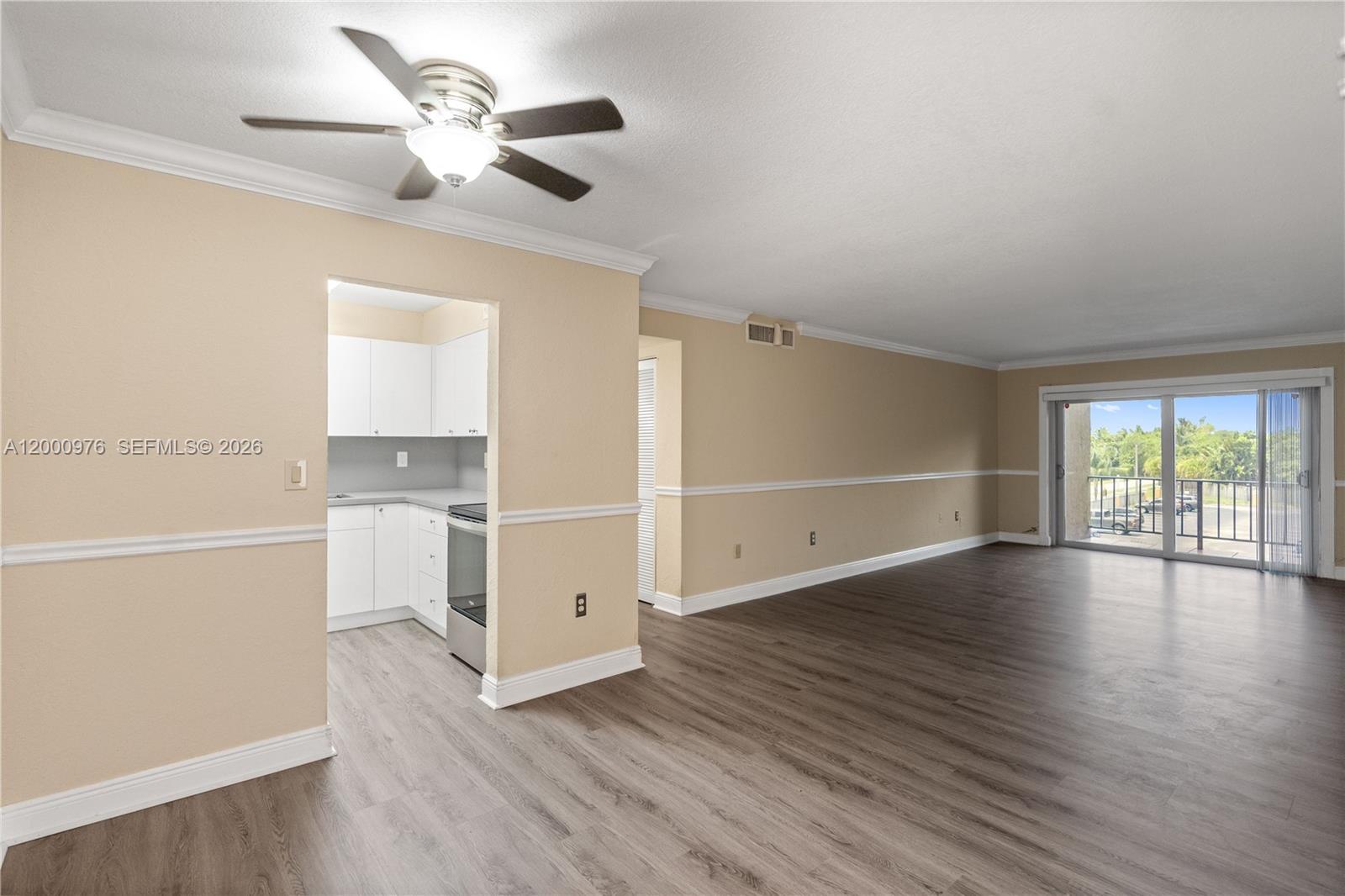 9441 Southwest 76th Street, Unit V32 Miami, FL 33173 - Photo 8 of 28 a view of an empty room with wooden floor and a window