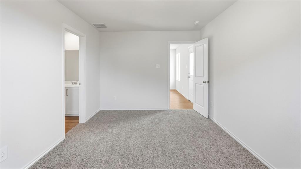 3535 Spring Time Street Forney, TX 75126 - Photo 14 of 23 Carpeted room with white walls, baseboards, and two doorways