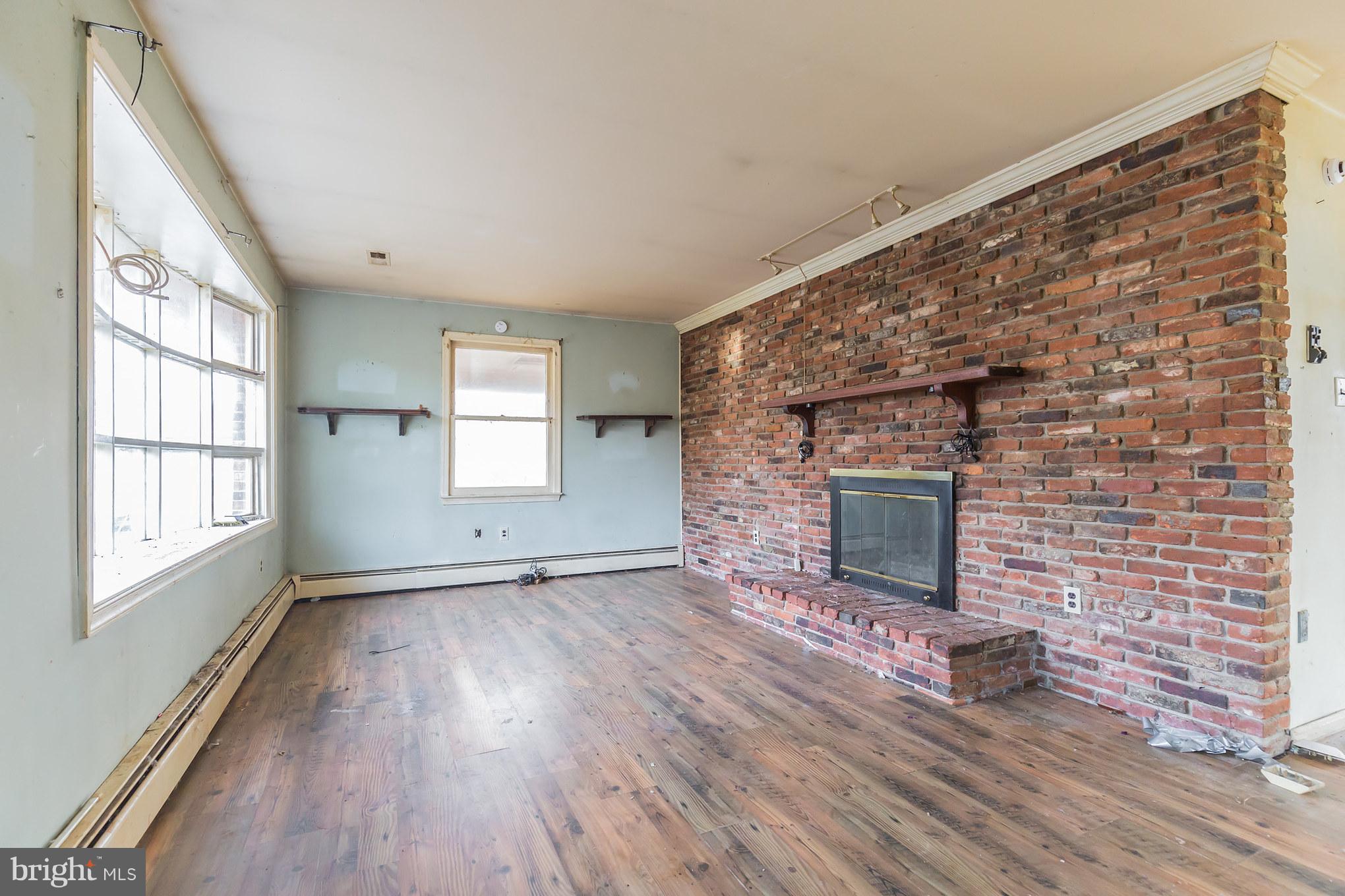 369 Friendship Road Friendship, MD 20758 - Photo 4 of 18 a view of empty room with wooden floor and fireplace