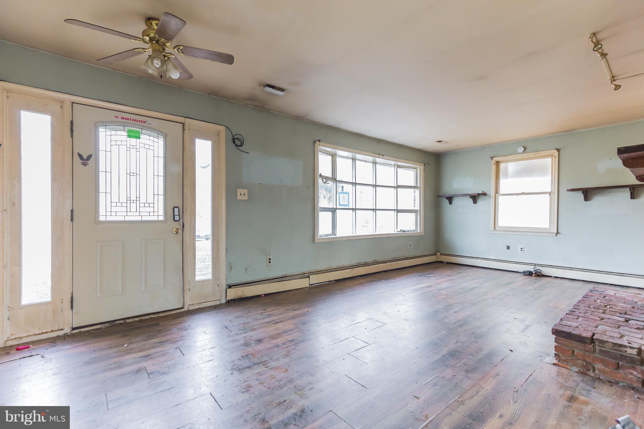 369 Friendship Road Friendship, MD 20758 - Photo 5 of 18 an empty room with wooden floor and windows