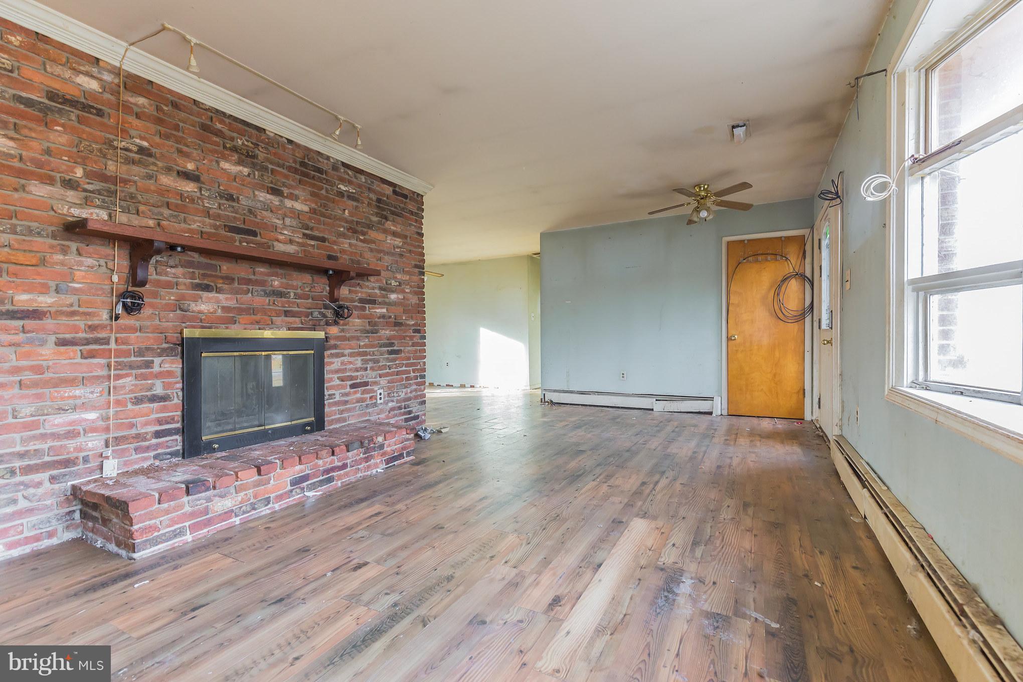 369 Friendship Road Friendship, MD 20758 - Photo 7 of 18 wooden floor in an empty room with a fireplace