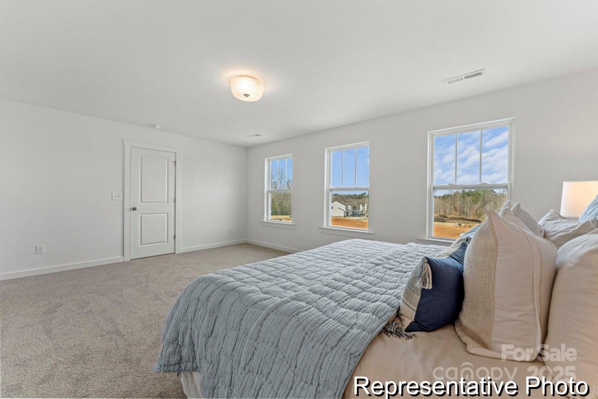 111 West Rice Planters Way, Unit 2P Statesville, NC 28625 - Photo 15 of 19 a bedroom with a bed wooden floor and lamp
