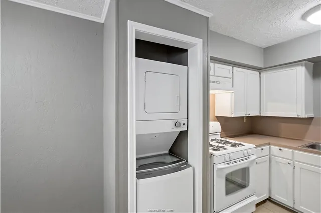 a kitchen with a stove and white cabinets