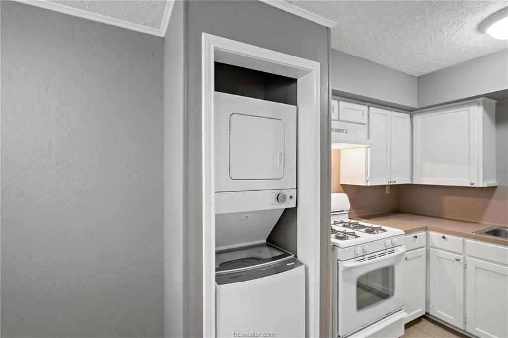 3906 Aspen Street, Unit C Bryan, TX 77801 - Photo 9 of 16 a kitchen with a stove and white cabinets