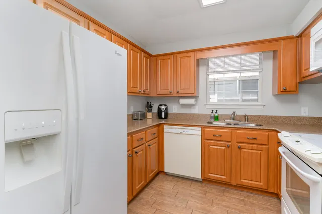 a kitchen with stainless steel appliances granite countertop a sink and a refrigerator