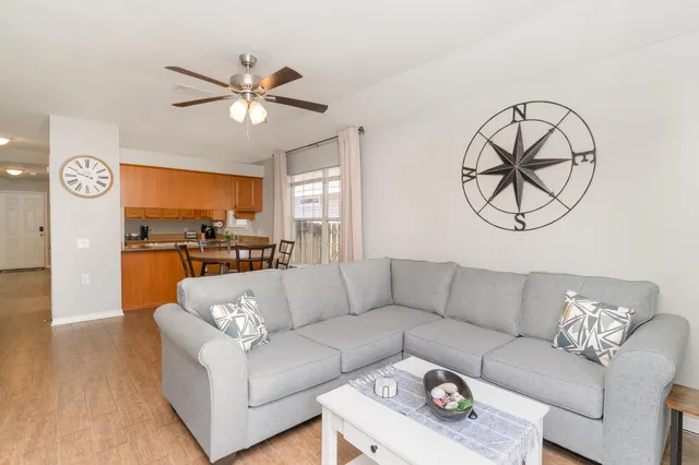 a living room with furniture and a view of kitchen