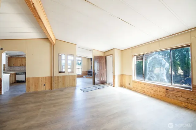 a view of a big room with wooden floor and windows
