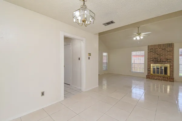 a view of a livingroom with a chandelier fan and windows