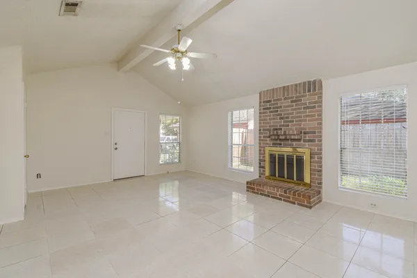 a view of an empty room with a fireplace and a window