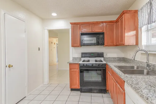 a kitchen with stainless steel appliances granite countertop a stove sink and cabinets