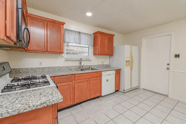 a kitchen with stainless steel appliances granite countertop a stove a sink and a refrigerator