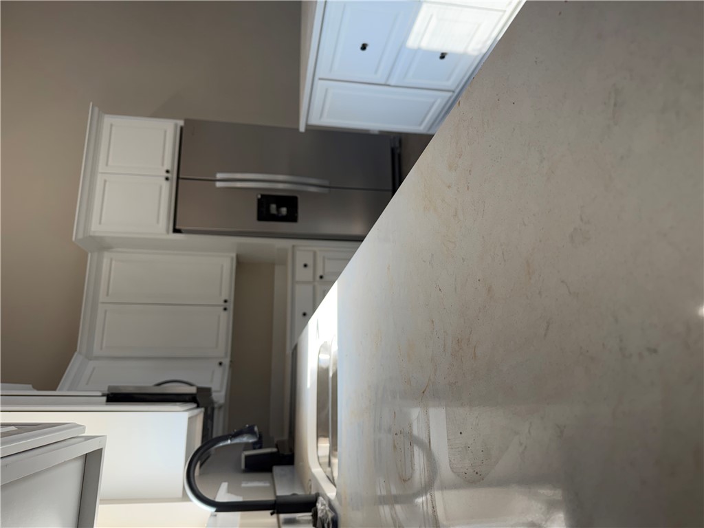 Solid surface countertop with an undermount sink and a matte black gooseneck faucet