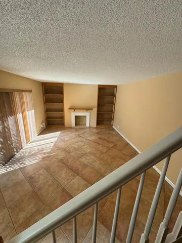 a view of a livingroom with an empty space and a fireplace