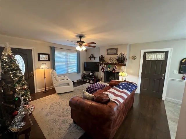 a view of a dining room and livingroom with furniture wooden floor a chandelier