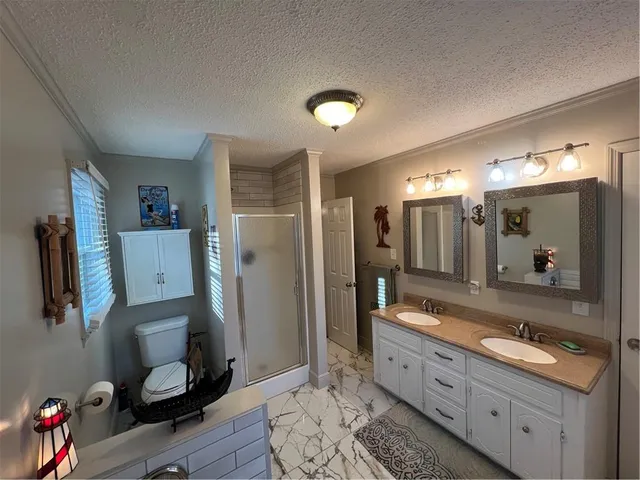 a bathroom with a sink a toilet and shower