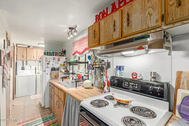 a kitchen with a refrigerator and a stove top oven