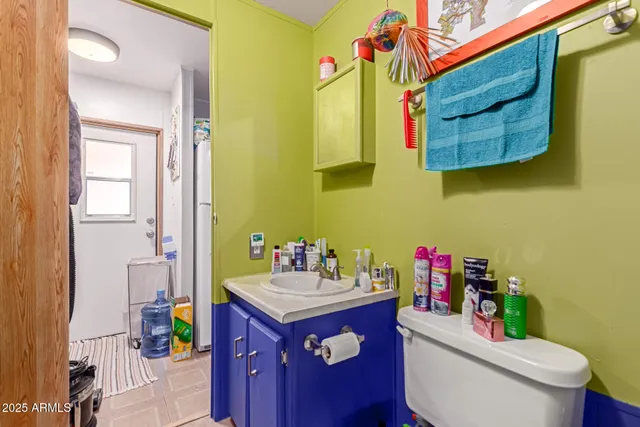 a bathroom with a sink vanity mirror and toilet