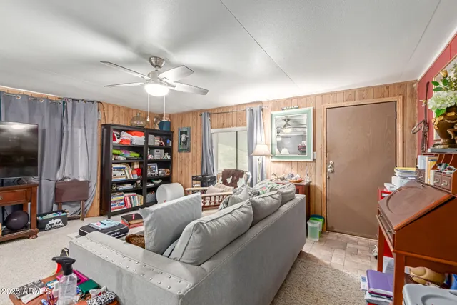 a living room with furniture a flat screen tv and a window