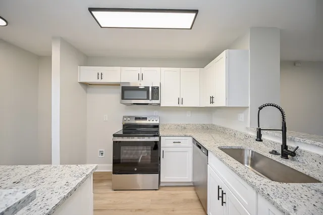 a kitchen with stainless steel appliances granite countertop a sink stove and refrigerator