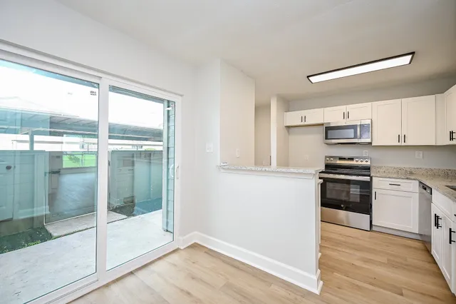a kitchen with granite countertop a stove and a refrigerator