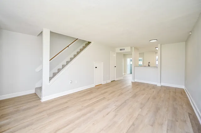 a view of empty room with wooden floor