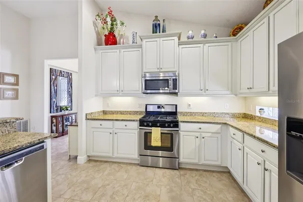 a kitchen with stainless steel appliances granite countertop a stove and white cabinets