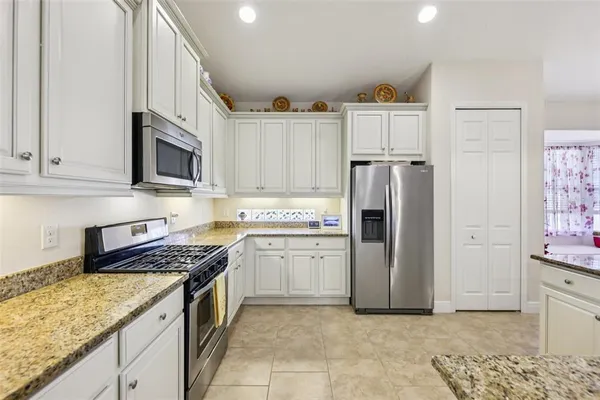 a kitchen with stainless steel appliances granite countertop a refrigerator stove and sink
