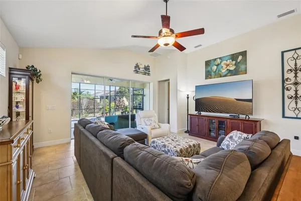 a living room with furniture a flat screen tv and a large window