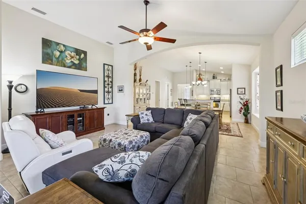 a living room with furniture kitchen view and a flat screen tv
