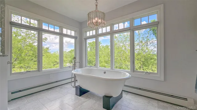 a spacious bathroom with a large tub and chandelier