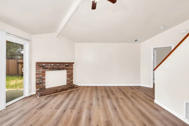 a view of empty room with wooden floor
