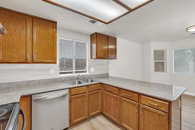 a kitchen with granite countertop cabinets sink and window