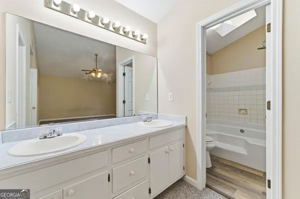 a bathroom with a granite countertop sink double and mirror