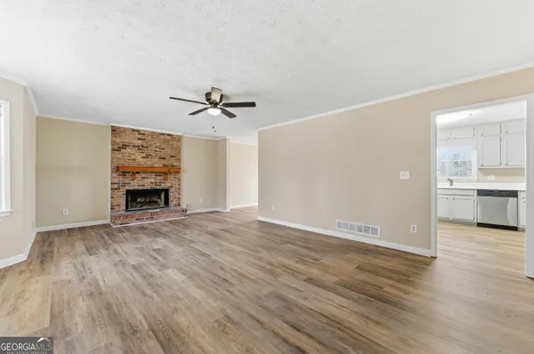 a view of an empty room with a fireplace and a window