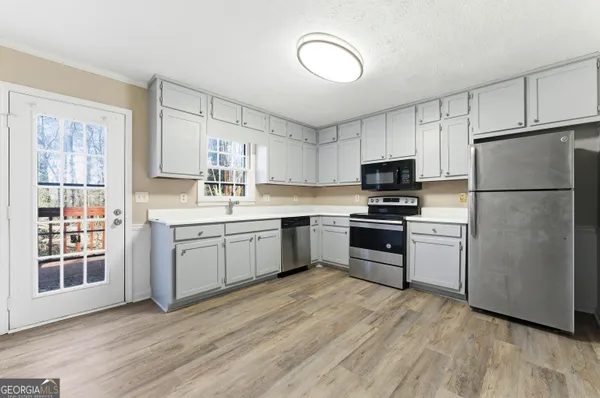 a kitchen with a refrigerator stove top oven and sink