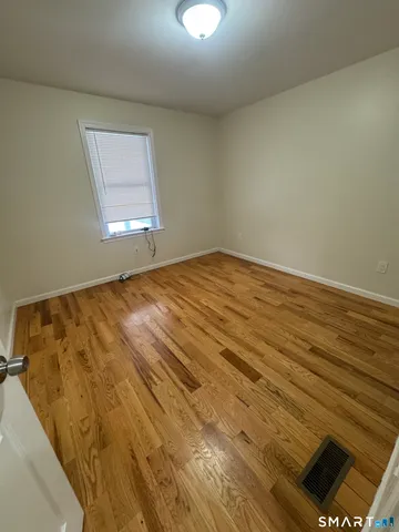 a view of a room with wooden floor and window