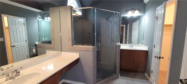 a bathroom with a double vanity sink mirror and shower