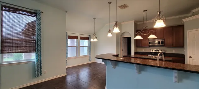 a kitchen with stainless steel appliances granite countertop a sink a stove and a wooden floors