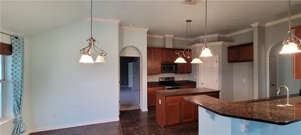 a kitchen with stainless steel appliances granite countertop a sink a stove and a refrigerator